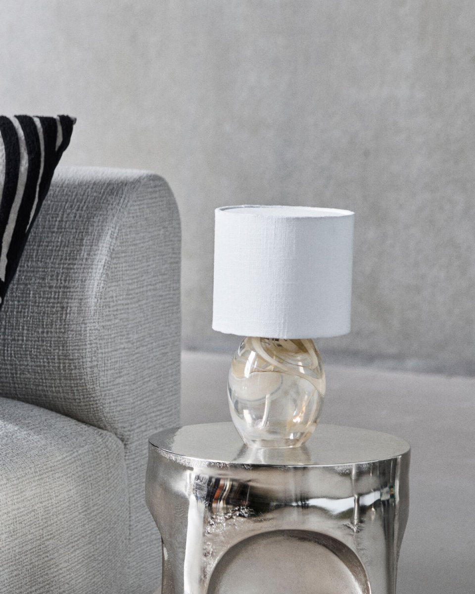 Hite 28cm Gebroken wit tafellamp Van House Doctor - De ronde glazen lampvoet is versierd met een prachtig gebroken wit wervelpatroon, waardoor elk exemplaar uniek is en de lamp een levendige uitstraling krijgt.