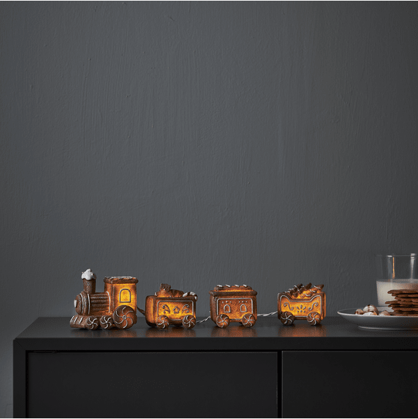 Gingerville Bruin Van Star Trading - De set bestaat uit een locomotief met drie wagons en een lichtsnoer.