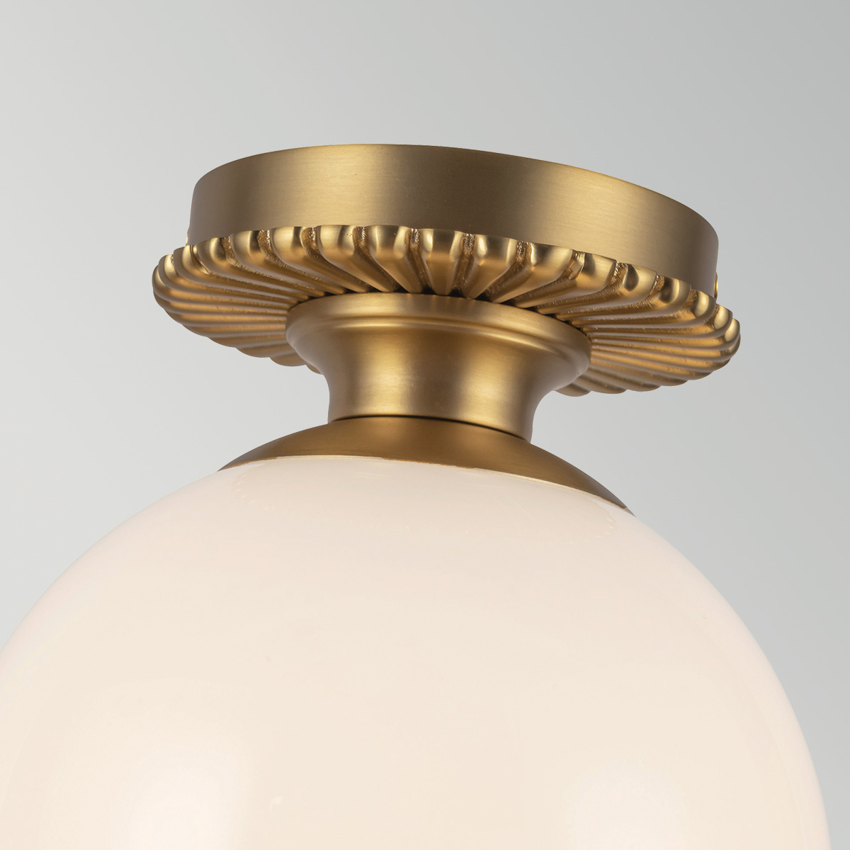 Otis Ø20 Geborsteld goud badkamerlamp Van Elstead Lighting - De ronde kap van glanzend opaalglas verbergt de lichtbron en verspreidt een zacht en aangenaam licht in de ruimte.