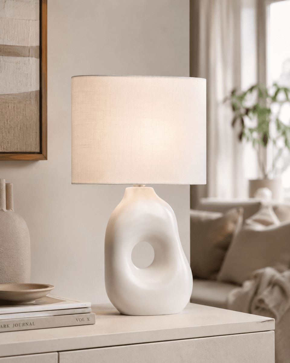 Pikazo 45cm Wit tafellamp Van Lampan - De Pikazo tafellamp heeft een unieke keramische voet met een sculpturale vorm en een decoratieve, doorlopende haardos, gecombineerd met een witte, ovale linnen kap.