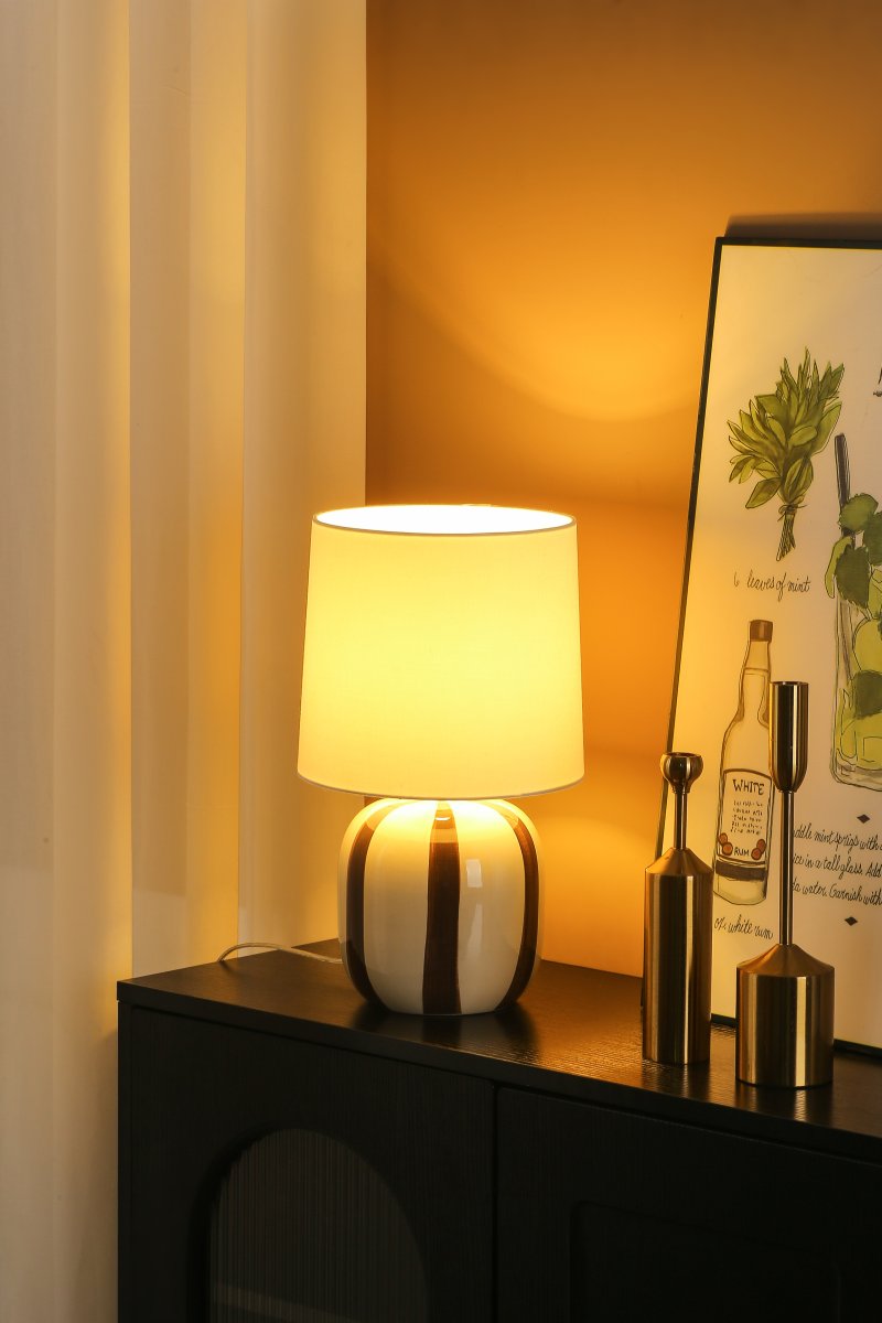 Pholca 38cm Wit/bruin tafellamp Van Nordic Lighting - De lampvoet is gemaakt van keramiek met een cr&egrave;mekleurige basis en bruine strepen die leven en karakter toevoegen.