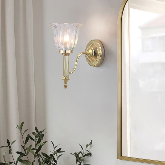 Carroll 14cm Gepolijst messing badkamerlamp Van Elstead Lighting - De kap van helder geribbeld glas verspreidt het licht prachtig en zorgt voor een stijlvolle sfeer in de badkamer.