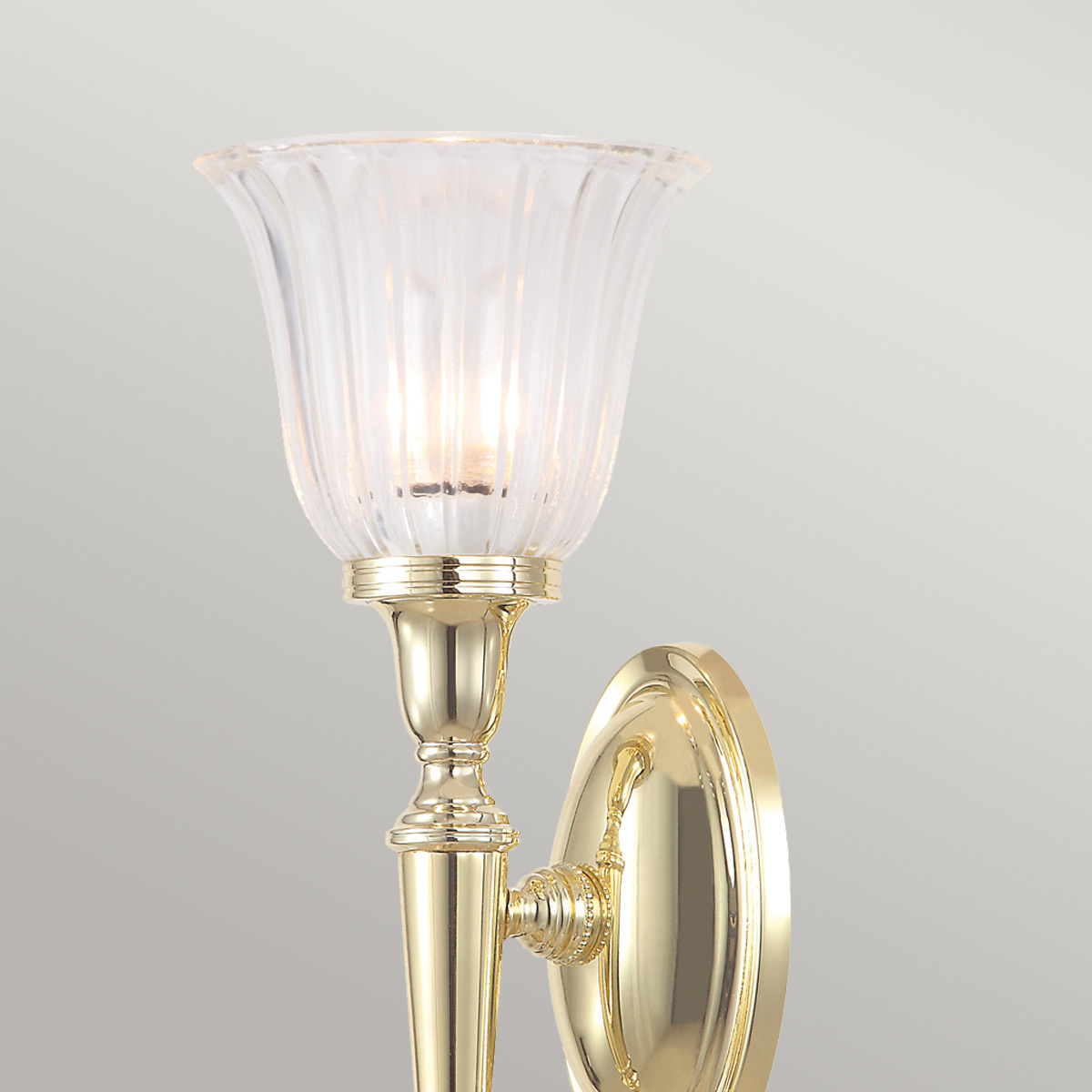 Dryden 33cm Gepolijst messing badkamerlamp Van Elstead Lighting - De lamp heeft prachtige glasdetails en is IP44-geclassificeerd, waardoor hij geschikt is voor gebruik in de badkamer.