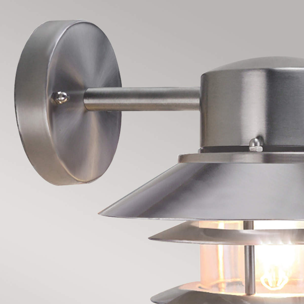 Copenhagen Ø22 Geborsteld staal buitenlamp Van Elstead Lighting - Tillverkad av rostfritt st&aring;l i borstad finish och glas, erbjuder den en h&aring;llbar och v&auml;dert&aring;lig konstruktion som passar perfekt f&ouml;r fasader, entr&eacute;er och uteplatser.