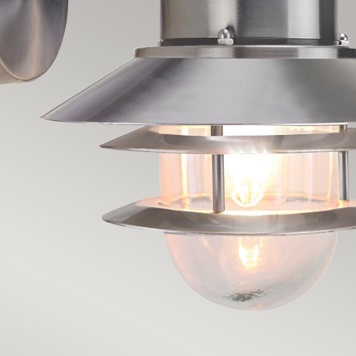 Copenhagen Ø22 Geborsteld staal buitenlamp Van Elstead Lighting - Tillverkad av rostfritt st&aring;l i borstad finish och glas, erbjuder den en h&aring;llbar och v&auml;dert&aring;lig konstruktion som passar perfekt f&ouml;r fasader, entr&eacute;er och uteplatser.