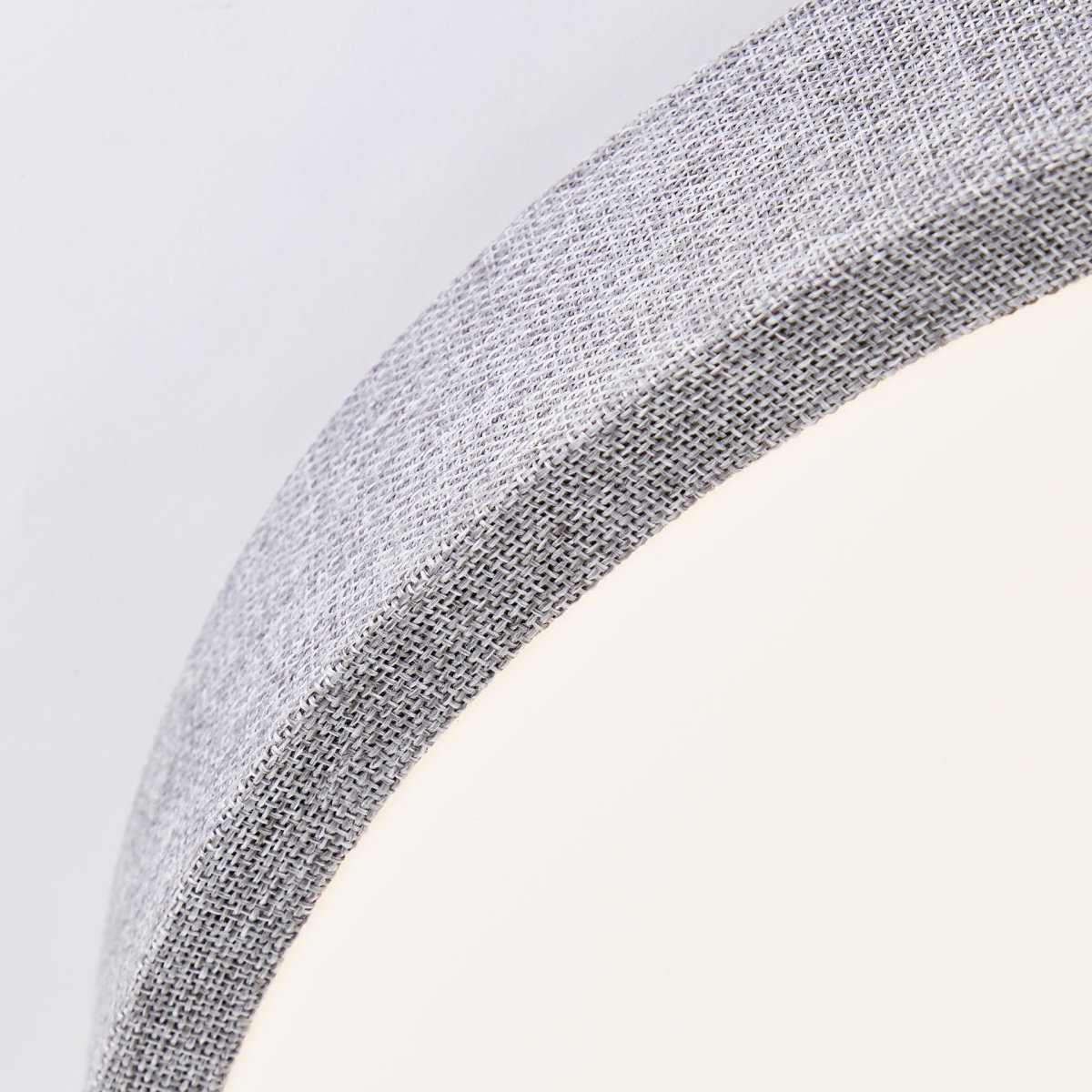 Filiz Ø38 Grijs plafondlamp Van Brilliant - Het grijze, met textiel beklede frame zorgt voor een zachte en gezellige uitstraling, terwijl de witte kunststof kap het licht gelijkmatig en zonder verblinding in de ruimte verspreidt.
