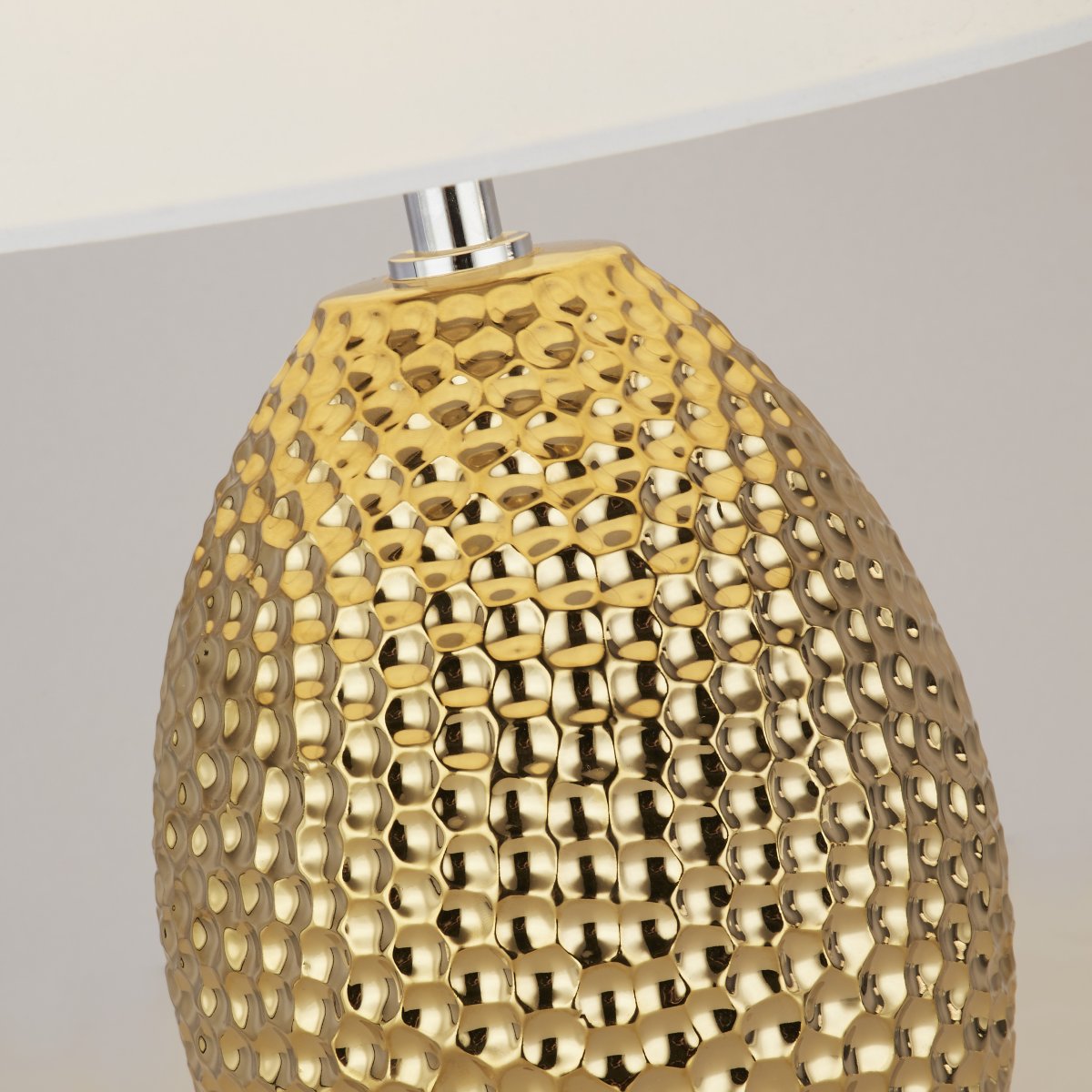 Nadine 30cm Goud tafellamp Van Searchlight - De getextureerde, goudkleurige keramische basis maakt een opvallende indruk, terwijl de neutrale crèmekleurige stoffen kap naadloos past bij elke interieurstijl.