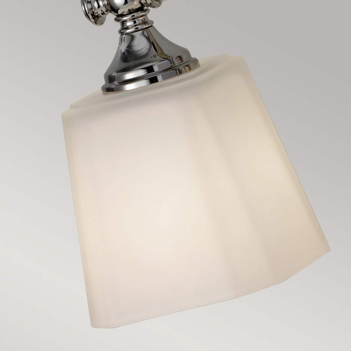 Concord 53cm Chroom badkamerlamp Van Elstead Lighting - Deze is voorzien van drie zacht gevormde, opaalwitte glaskappen die een aangenaam en egaal licht verspreiden, ideaal voor badkamers.