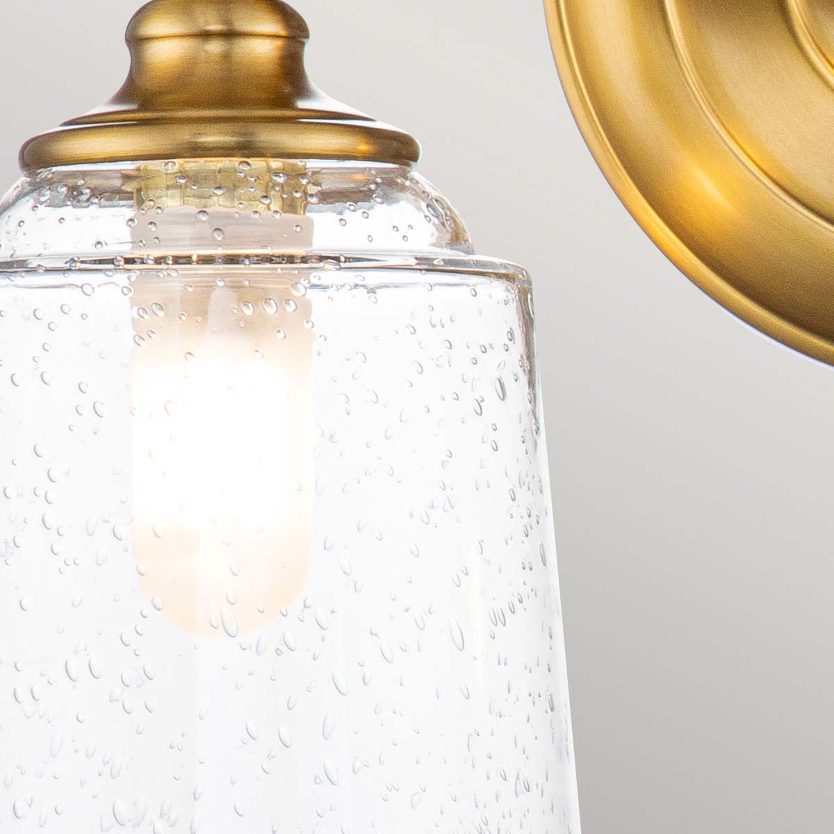 Huguenot Lake 33cm Messing badkamerlamp Van Elstead Lighting - De elegante ronde details en de met de hand gesneden monturen geven een gevoel van traditioneel vakmanschap, terwijl het heldere, gestructureerde glas een zacht en uitnodigend licht creëert.