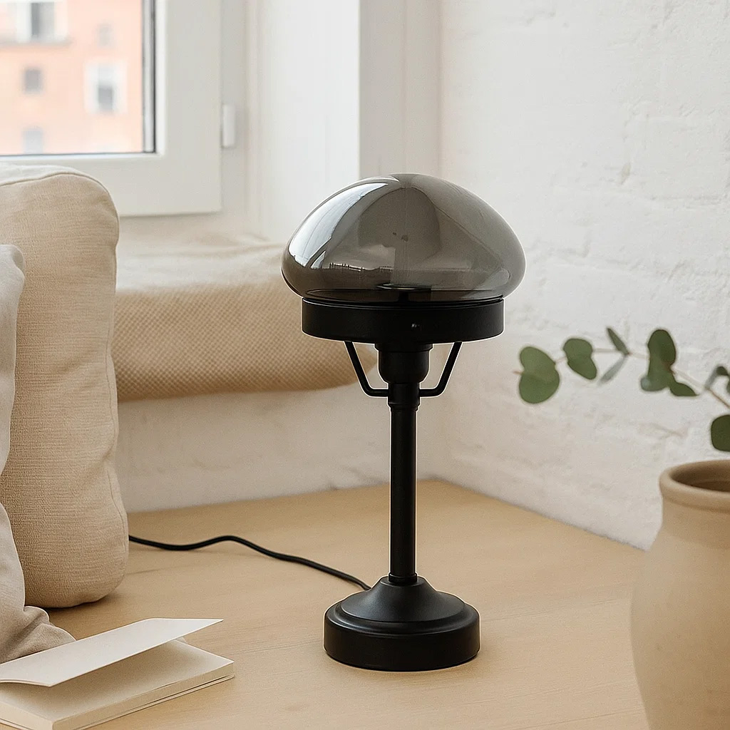 Jas 30cm Zwart tafellamp Van Lampan - Hij heeft een zwarte metalen voet en een koepelvormige lampenkap van rookglas die een zacht en aangenaam licht verspreidt.