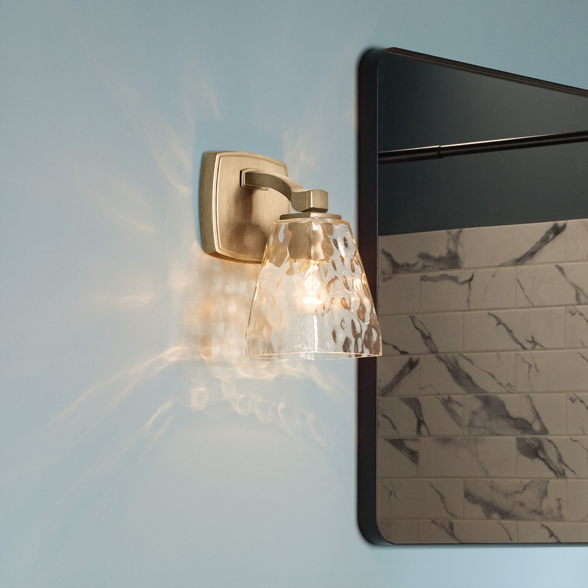 Marant 24cm Bronzen badkamerlamp Van Elstead Lighting - De kap van helder, getextureerd glas met een waterachtig patroon geeft de lamp een levendige uitstraling en zorgt voor prachtige lichtreflecties wanneer de lamp brandt.