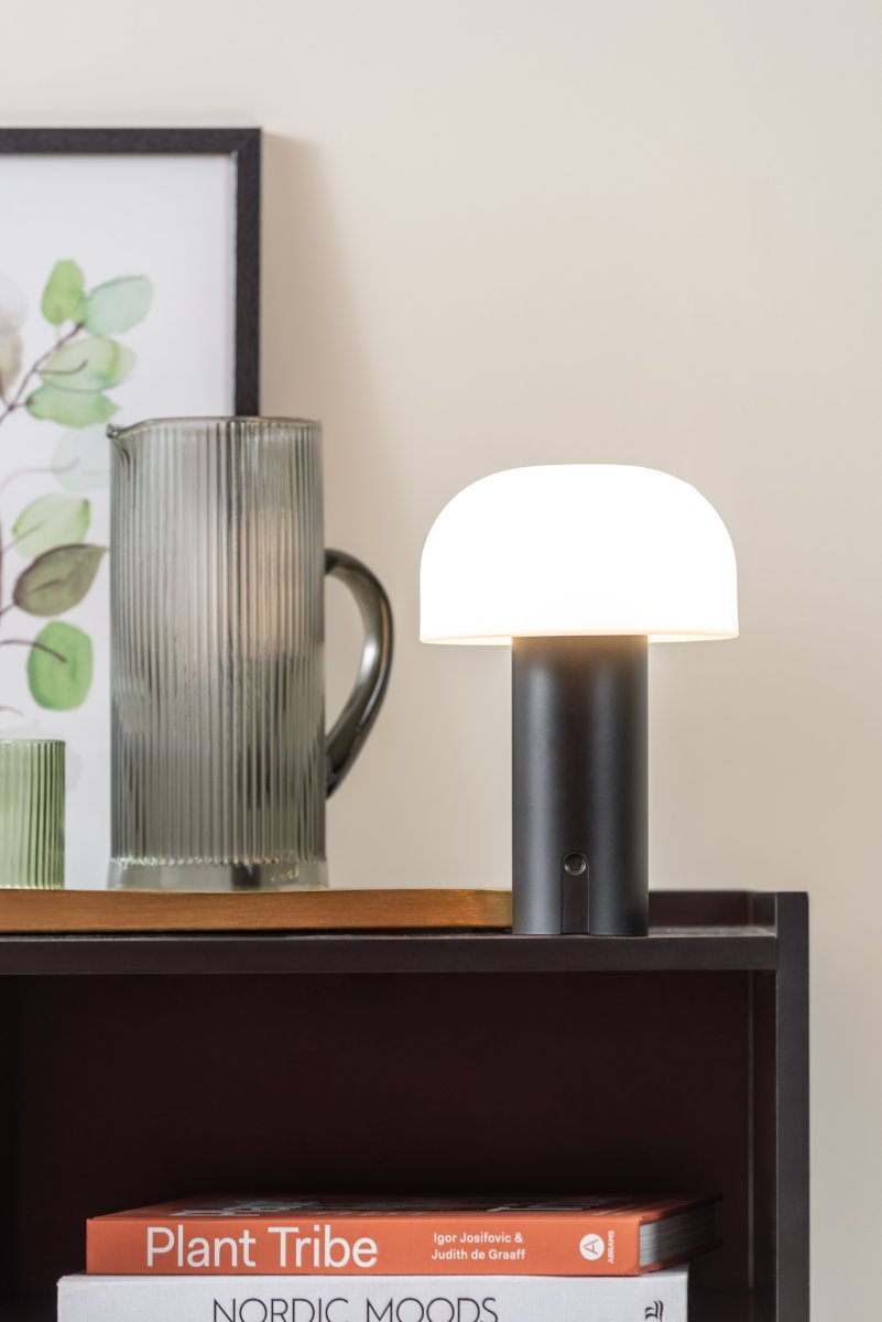 Luca LED 22cm Zwart Draagbare Van Leitmotiv - De lamp is gemaakt van metaal met een matzwarte afwerking en heeft een melkwitte plastic kap die een zacht en aangenaam licht verspreidt.