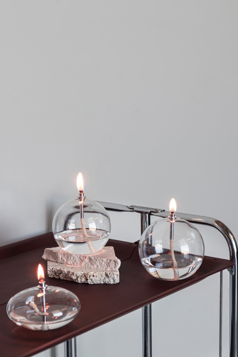 Oljelampa Aura Mellan Helder glas Van Mette Ditmer - Wanneer de lamp laag brandt, verspreidt hij een zacht, warm licht dat een rustige en gezellige sfeer cre&euml;ert.