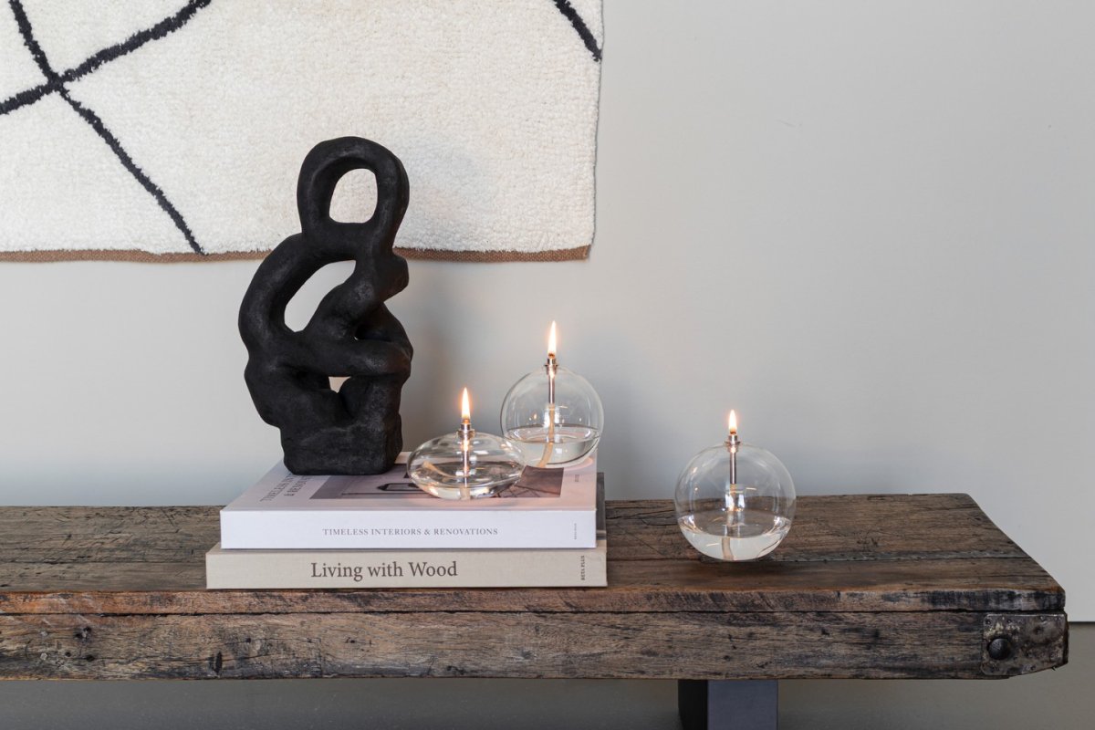 Oljelampa Aura Stor Helder glas Van Mette Ditmer - Het elegante ontwerp en het rookglas verspreiden een zacht, warm licht dat een kalme en gezellige sfeer geeft.