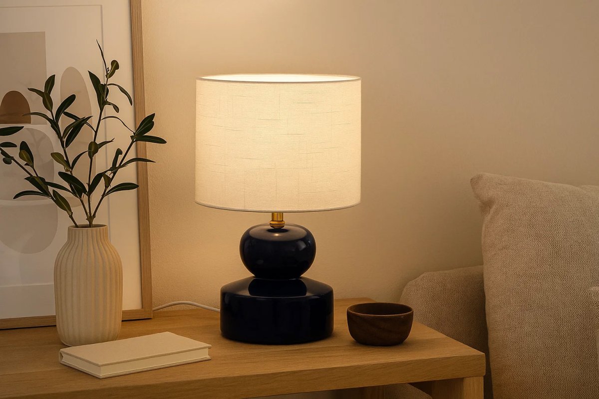 Muschi 36cm Blauw tafellamp Van Nordic Lighting - De Muschi tafellamp heeft een blauwe, glanzende keramische voet met zacht afgeronde vormen en een witte linnen kap.