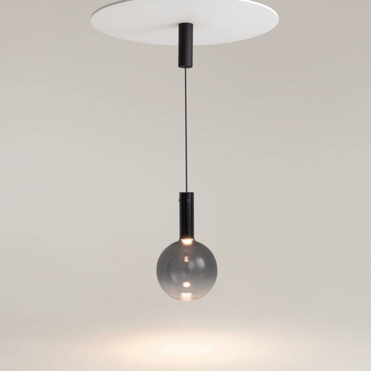Nebula Ø25 Zwart hanglamp Van Maytoni - De blauwe glazen bol, met een verloop van donker aan de bovenkant naar bijna transparant aan de onderkant, geeft een zwevend effect.