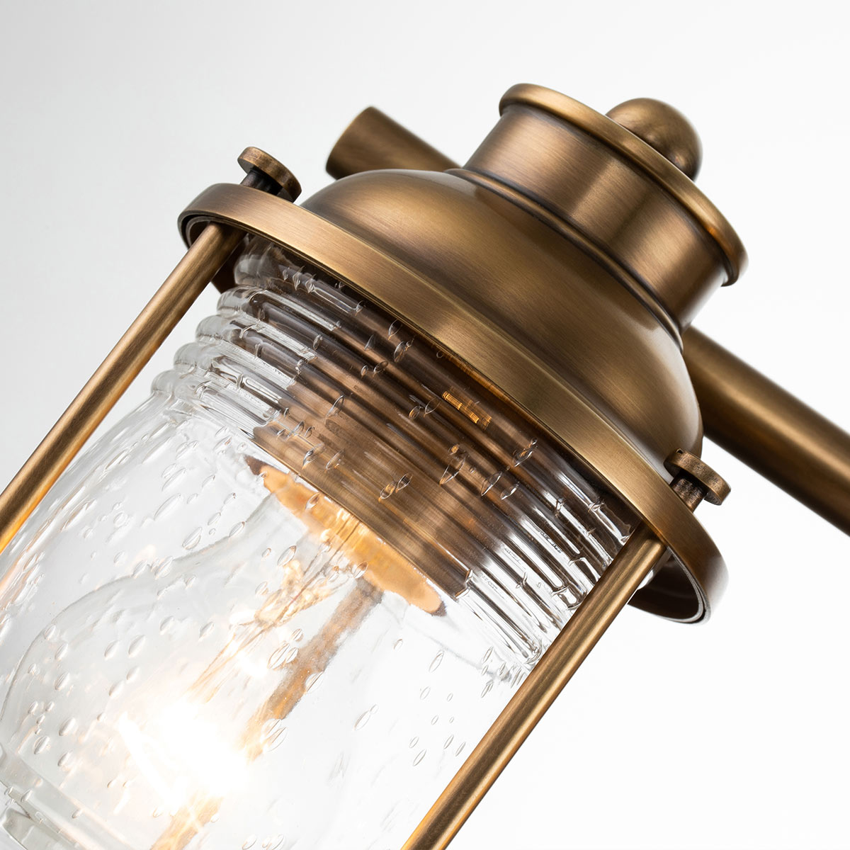 Ashland Bay 60cm Messing badkamerlamp Van Elstead Lighting - Gemaakt van staal en glas, heeft het een luxueuze messing afwerking en drie prachtig getextureerde glazen die het licht verspreiden.