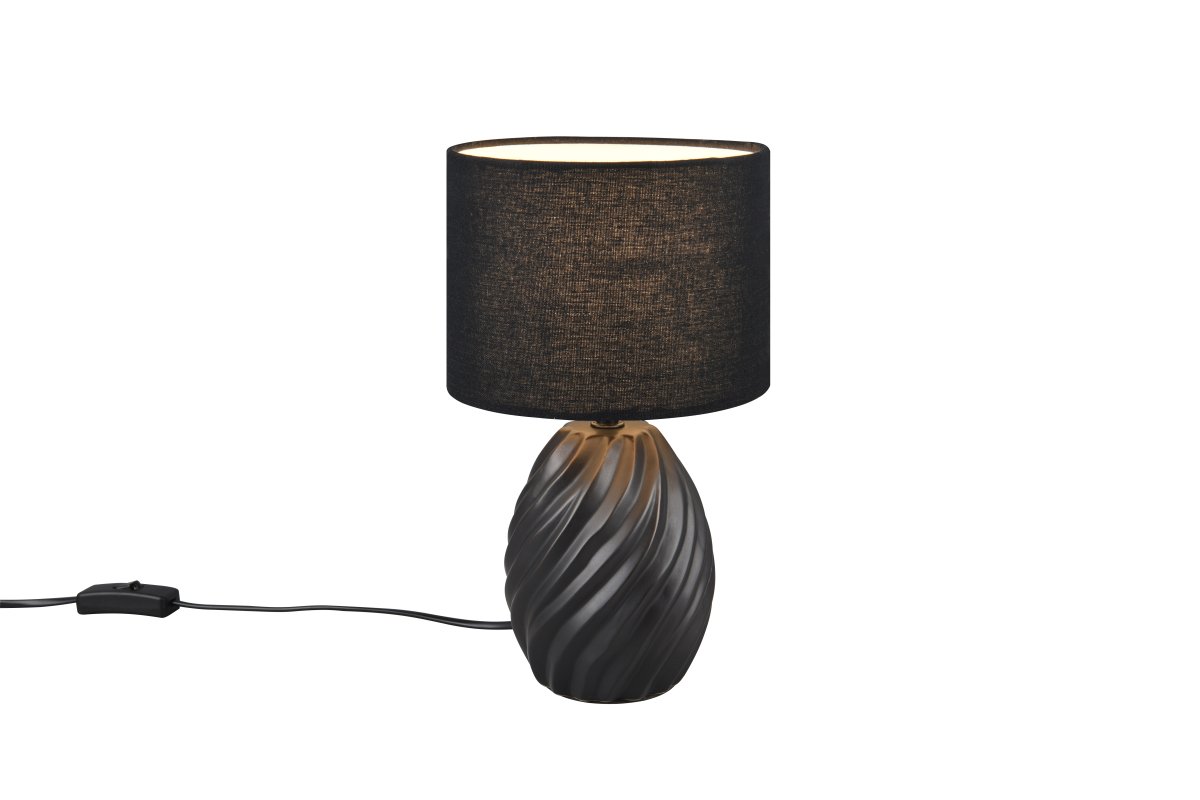 Melva 30cm Zwart tafellamp Van Trio Lighting - De elegante mix van matzwart keramiek en de zachte stoffen kap zorgt voor een verfijnde indruk, terwijl de golvende keramische voet een fascinerend lichtspel creëert.