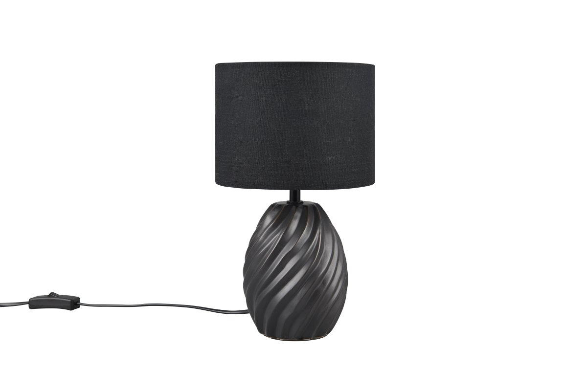 Melva 30cm Zwart tafellamp Van Trio Lighting - De elegante mix van matzwart keramiek en de zachte stoffen kap zorgt voor een verfijnde indruk, terwijl de golvende keramische voet een fascinerend lichtspel creëert.