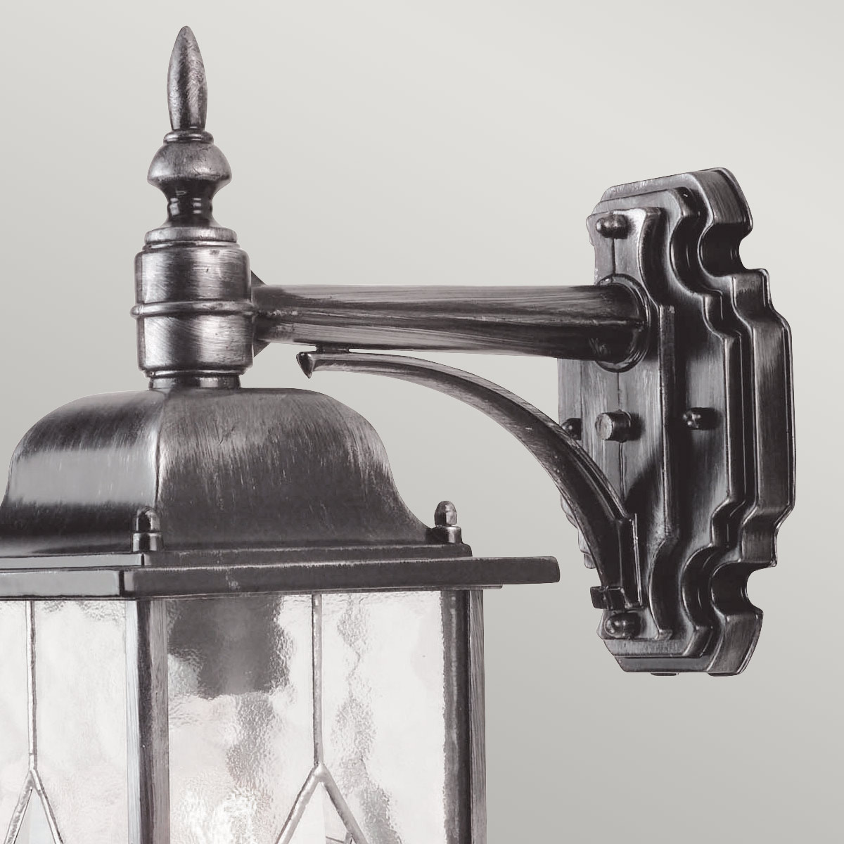 Wexford Zilver buitenlamp Van Elstead Lighting - Wexford is een klassieke wandlamp voor buiten, gemaakt van aluminium met een elegante donkerzilveren afwerking en decoratieve glazen secties met een loodpatroon.