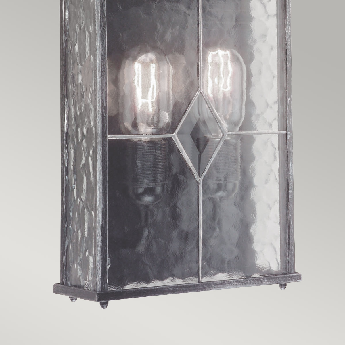 Wexford Zilver buitenlamp Van Elstead Lighting - Wexford is een klassieke buitenwandlamp, gemaakt van aluminium met een elegante donkerzilveren afwerking en decoratieve glazen panelen met een loodpatroon.
