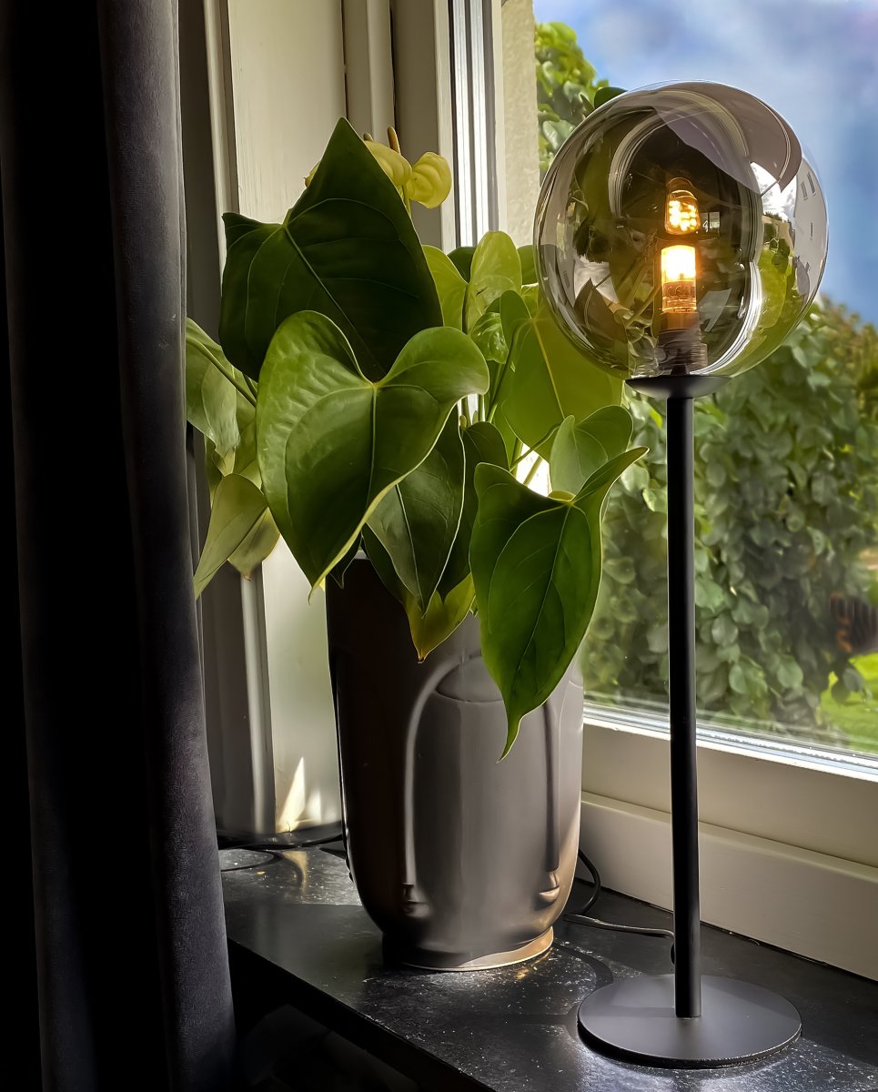Molekyl 43cm Rookgrijs tafellamp Van Aneta Lighting - Met zijn kap van gerookt glas en minimalistische metalen voet zorgt hij voor een verfijnde verlichting die in elke kamer een warme sfeer cre&euml;ert.